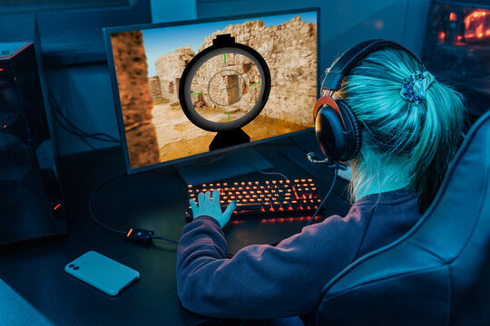 Gamer wearing headset and playing esports on desktop PC