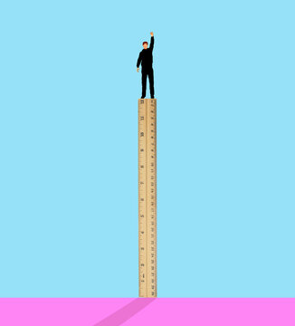 Man standing on ruler against colored background