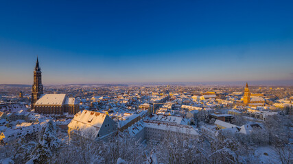 Scenic overview from Castle Trausnitz over the town Landshut, Lower Bavaria with snow covered walls and roofs in winter on sunny day