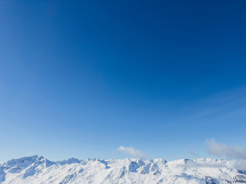 Austria, Tyrol, Axamer Lizum, Clear blue sky over snowcapped peaks of Alps - Powered by Adobe