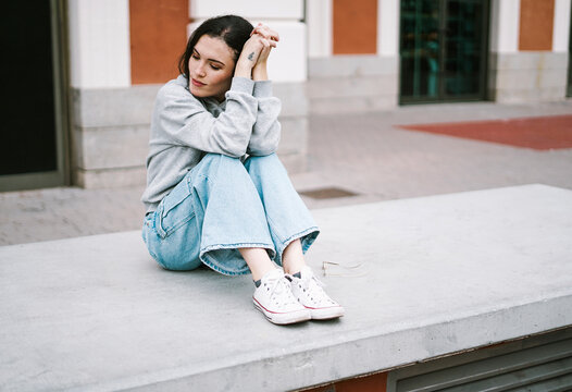 Young woman sitting on concrete bench