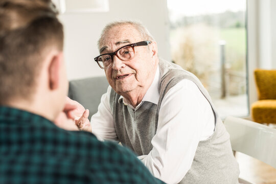 Senior man talking to grandson at home