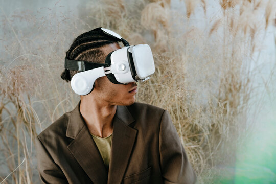 Young businessman wearing virtual reality simulator in garden