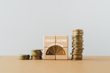 CREDIT SCORE text with indicator gauge meter on wooden cube block with stack of coins, copy space ...