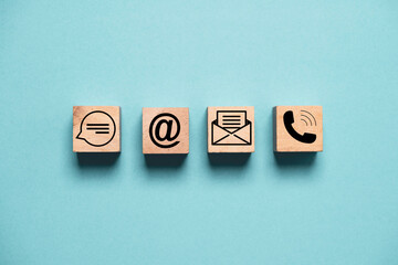 Contact icons include message address e-mail and telephone on wooden block cube and blue background...