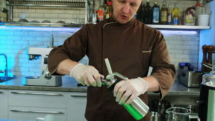 Man screws co2 charger of whipping siphon for replacement. Chef uses carbon dioxide cylinders for...