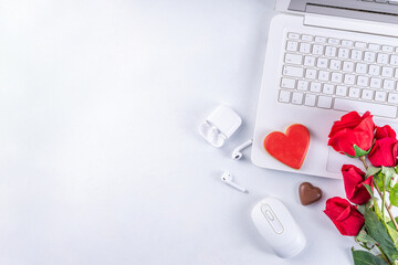 Woman using laptop with red roses