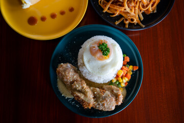 Chicken cordon bleu with rice and egg served in a plate