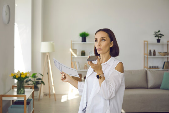Busy woman recording voice message. Serious lady talking on speaker mode. Business executive manager holding phone, using messenger app, sending employee audio text, giving order, making arrangement