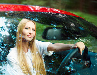Beautiful blond young woman in a sports car