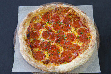 Hot pepperoni pizza with green basil close-up