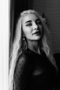 Portrait of a young beautiful blonde girl in vintage style. Black and white photo.