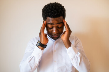 Portrait of young businessman who is tired and having headache.