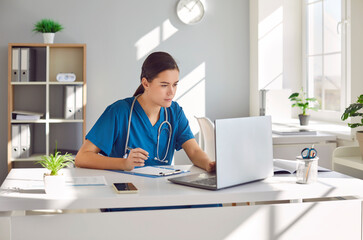 In the virtual realm of healthcare, Focused woman doctor or nurse using a laptop computer in...