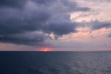 Naklejka na ściany i meble Sunset over the mediterranean sea on a cloudy day