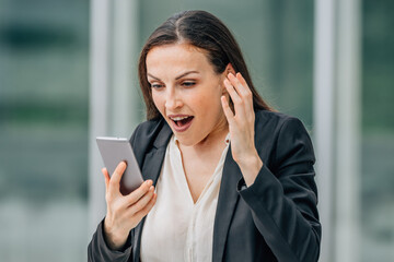 business woman with mobile phone and surprised expression