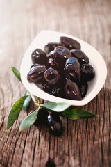 Bowl with black olives on table