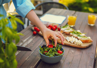 Young woman cooking dinner at the home in the garden