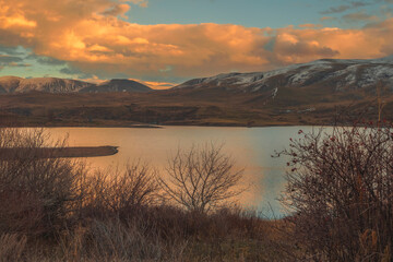 Golden hour with sunset clouds over Kechut Reservoir. Travel destination Armenia