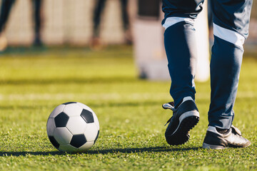 Fototapeta premium Football Player in Men's Soccer Pants With Soccer Ball on Winter Training Unit. Football Training Session During Winter Time