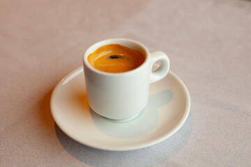 A cup of coffee with foam on a beige background