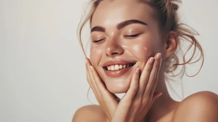 Fotobehang Skincare. Woman with beautiful face touching healthy facial skin. Woman smiling while touching her flawless glowy skin with copy space for your advertisement, skincare © ND STOCK