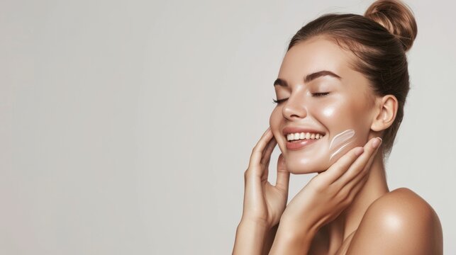 Skincare. Woman with beautiful face touching healthy facial skin. Woman smiling while touching her flawless glowy skin with copy space for your advertisement, skincare