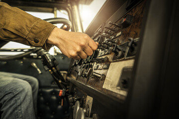 Driver Switching Dashboard Buttons Inside His Classic Semi Truck