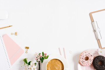 Trendy stylish frame for a female blogger, freelancer: notebooks, tablet, stationery, donut on a plate, apple blossoms on a white background with a place to copy