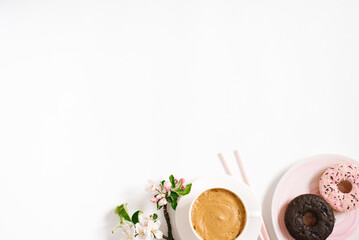 Stylish flat lay with cappuccino cup, apple blossoms, donuts on a white background with space...