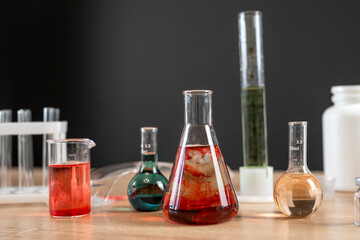 Glass laboratory flask and beaker with liquids for analys or experiment in desk
