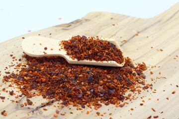 flakes of hot chilli paprica in wooden spoon