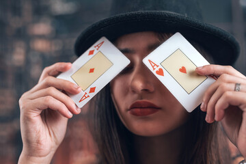 Beautiful caucasian woman showing a poker card near her red lips, closeup