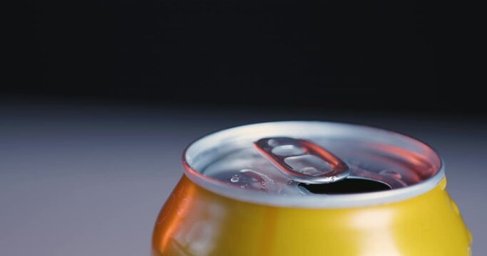 Yellow soda can with condensed water, camera pan, close-up