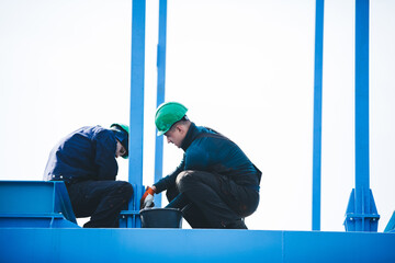 Manual workers working at shipyard construction site