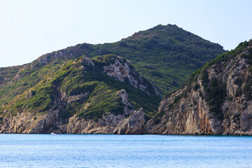 Sandy beach by the sea near Agios Georgios on the island of Corfu under a blue sky