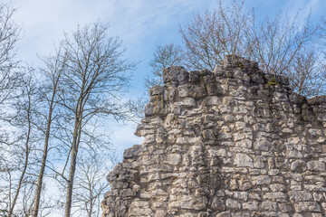 Mauerreste der Burgruine Hohenstein bei Oberstetten auf der schwäbischen Alb mit kahlen Bäumen und blauem Himmel mit Wolken