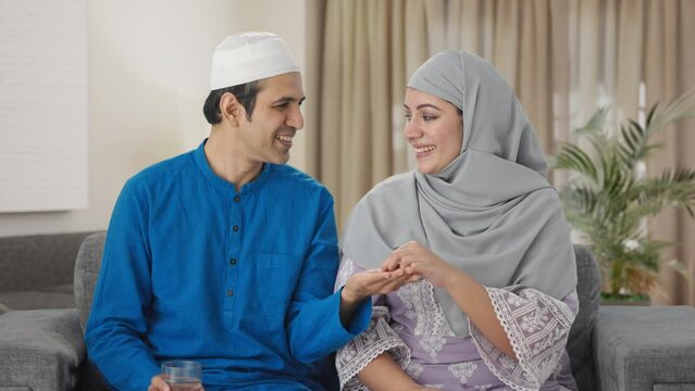 Happy Muslim husband giving medicine to his wife