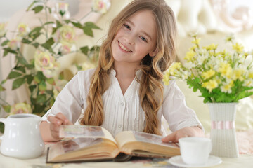 Close up portrait of young girl reading interesting big book