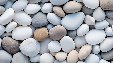 Gartenposter Steine ​​im Sand A group of white pebble stones stacked together.