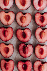 halves of cherries laid out in rows on a crumpled paper background