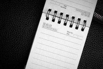 An empty notebook on a black background, with space for writing. Task planning. The businessman's notebook