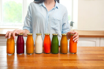 Diet nutrition with detox juice. Healthy woman posing with fresh juice bottles of  detox smoothie.