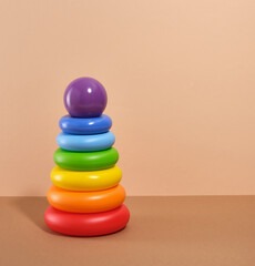 Pyramid with colored rings and round purple ball on top. Copy space for text. Toys for kids.