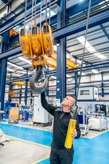 Operator using an industrial crane in a logistics factory