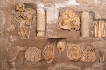 Close-up on broken pieces of ancient decorative sculptures in marble exhibited in a museum in Rome