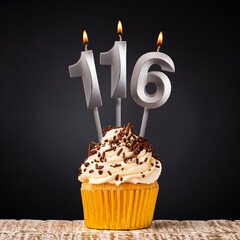 Birthday candle number 116 - Anniversary cupcake on black background