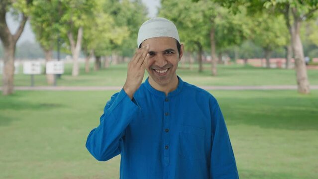 Happy Muslim man doing Adaab and greetings in park