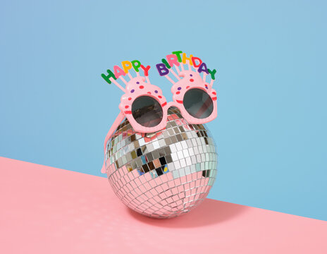 A glowing disco ball and glasses. Birthday party preparations.