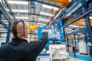 Worker directing the maneuvers of an industrial crane